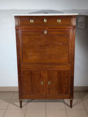 a wooden cabinet with a marble top on a tile floor