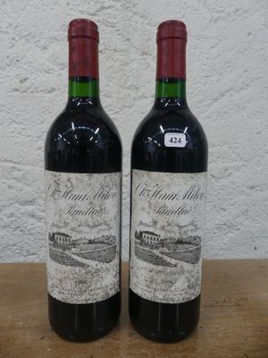 deux bouteilles de vin rouge posées sur une table en bois