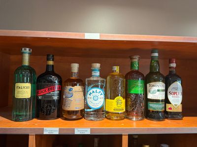 de nombreuses bouteilles d'alcool sur une étagère dans un magasin de spiritueux