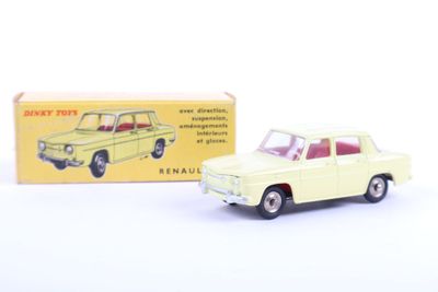 yellow toy car in front of a box of toys on a white surface