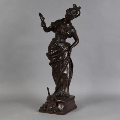 une statue en bronze représentant une femme tenant un oiseau dans la main