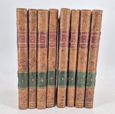 six old books are lined up in a row on a white surface
