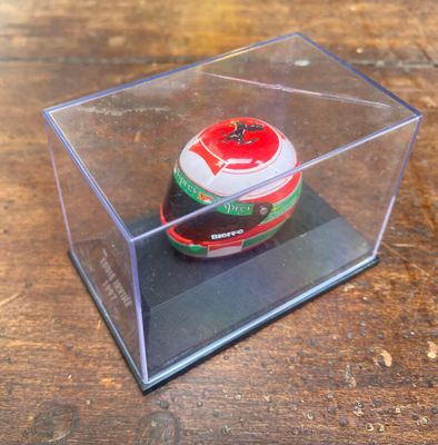 un petit objet en plastique dans une boîte transparente posée sur une table en bois