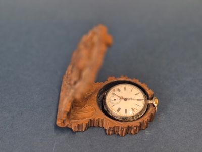 une petite horloge en bois en forme de feuille