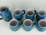 six blue mugs sitting next to each other on a table
