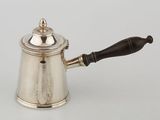 a silver coffee pot with a wooden handle on a white surface
