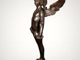 a bronze statue of an angel with wings on a marble base