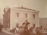 an old photo of a large house with a clock on it