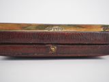 an old wooden box with a metal handle on a white surface