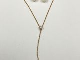 un ensemble composé d'un collier et de boucles d'oreilles en or, rehaussés de perles sur fond blanc