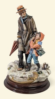 figurine représentant un homme et un enfant avec un parapluie