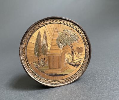 une image représentant une assiette en or sur laquelle figurent une maison et des arbres