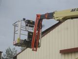 a man on a cherry picker working on the side of a building