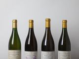 quatre bouteilles de vin sont alignées sur une table