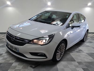 L'Opel blanche est garée sur un sol carrelé à damier.