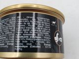 an open can of canned dog food on a white surface