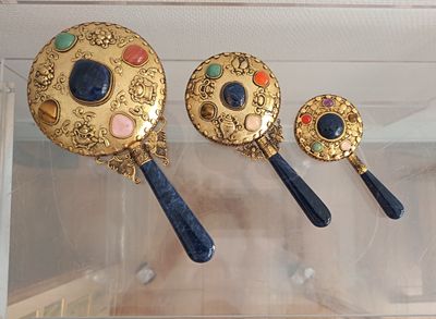 a display case with three mirrors and a pair of spoons