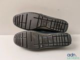 pair of black leather shoes on a white surface with a white background