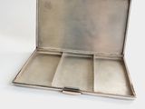 a silver box with three compartments on a white surface