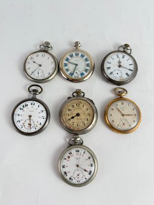 plusieurs types de montres de poche sont présentés sur une surface blanche