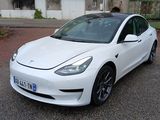 a white tesla car parked on the street in front of a building
