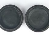 a pair of black plastic plates on a white surface