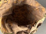 a brown bag with a black handle on a gray surface