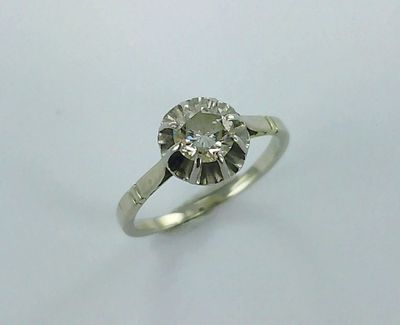 a close up of a diamond ring on a white surface