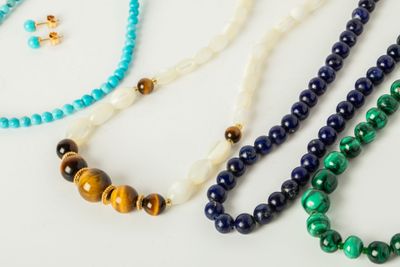 Quatre colliers de perles dont un collier de perles de lapis…