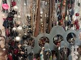many necklaces and bracelets hanging on a rack