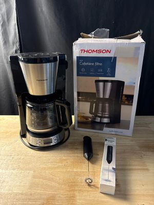 une cafetière posée sur une table à côté d'une boîte
