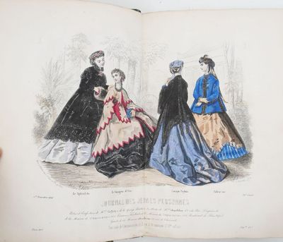 un livre ouvert sur lequel figure le dessin d'une femme en robe bleue et de trois autres femmes en robes noires