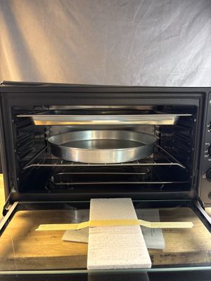 an open oven with a pan in it on a counter
