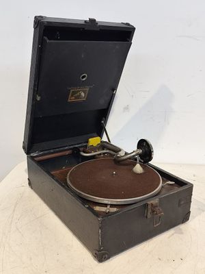 un vieux tourne-disque posé sur une table près d'un mur blanc