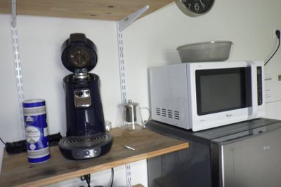 un micro-ondes et une cafetière posés sur une étagère dans une cuisine