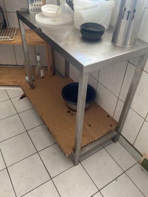 a small kitchen with a metal table and a sink