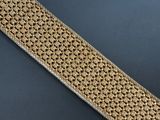 a close up of a gold and silver bracelet on a black surface