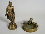 two bronze figurines of a man and a woman sitting on a fountain