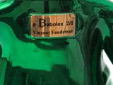 a green vase that has a label on the top of it