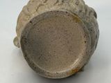 a close up of a vase on a white surface