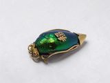 a gold and green beetle charm with a gold plated base