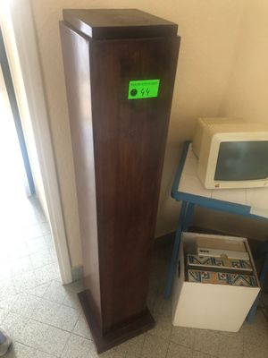 une grande tour en bois surmontée d'une horloge verte
