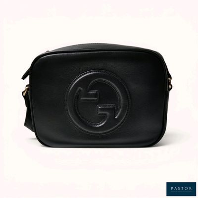 a black leather gucci bag with a logo on the front