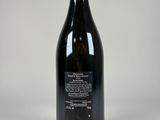 an empty bottle of wine sitting on top of a white table