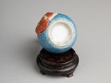 porcelain figurine of a fish in a bowl on a wooden stand