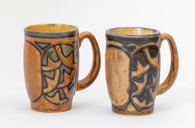 deux tasses à café posées l'une à côté de l'autre sur une surface blanche