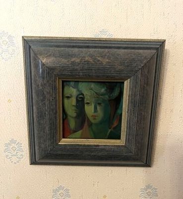 une photo d'un tableau accroché au mur au-dessus des toilettes