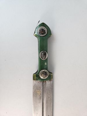 a green and silver knife on a white surface