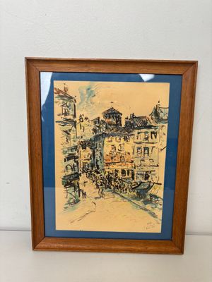 tableau représentant une scène de rue, encadré dans un cadre en bois