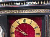 a clock that is sitting on a table with a red velvet cover